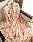 Woman posing in the Floral-Print Chiffon Bow-Neck Long-Sleeve Dress, airy 100 % polyester chiffon and self-tie bow collar give romantic 70s vibes—your breathable 70-85 °F spring-to-summer statement.