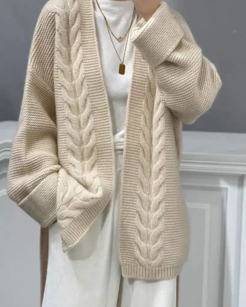 Woman layering the Gentle Short Cable Wool Cardigan, 100 % superfine Merino and chunky cable knit give nautical 90s vibes—your cozy yet breathable 60-75 °F spring-fall layer.