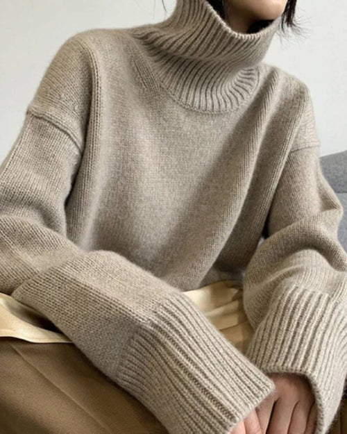 Merino-wool pullover, loose high-neck silhouette, dropped shoulders, ribbed cuffs, heather taupe—breathable warmth for winter layering or solo wear.
