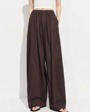 Premium brown loose-fit high-waisted wide-leg pants crafted from a soft lyocell blend, offering a breathable composition and an adjustable drawstring waist for a sophisticated loungewear or daily look.