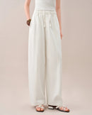 High-waisted loose-fitting curved pants featuring a relaxed silhouette and a unique curved leg shape. These comfortable trousers offer a trendy, flowy fit perfect for casual daily wear and effortless chic styling.