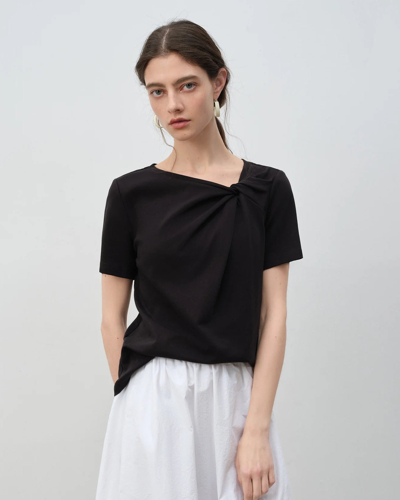 Women's asymmetrical knotted short-sleeved T-shirt, featuring 100% cotton fabric and sculptural knot detail for effortless summer weekend outings or morning errands.
