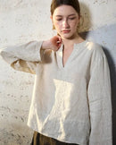 A relaxed loose-fit linen shirt featuring a classic V-neckline and long sleeves. This lightweight garment is crafted from breathable linen fabric, offering a comfortable drape perfect for layering or wearing alone in transitional weather.