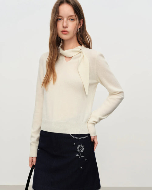 A soft wool knit sweater featuring a delicate openwork design and a flattering V-neckline. This lightweight garment drapes beautifully, offering a breathable texture that makes it an essential layering piece for transitional weather during the spring and autumn seasons.