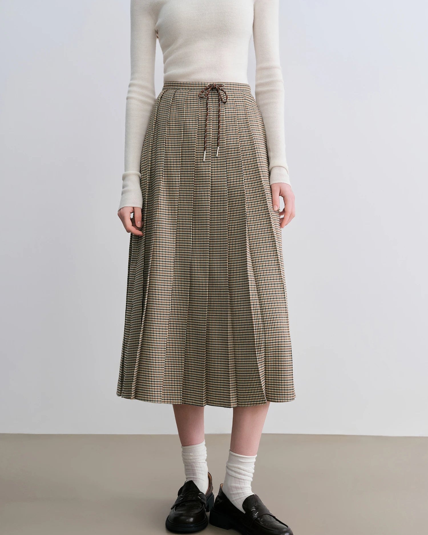 Women's coffee plaid pleated A-line skirt, featuring structured polyester-spandex fabric and classic gingham pattern for campus mornings or weekend outings elegance.