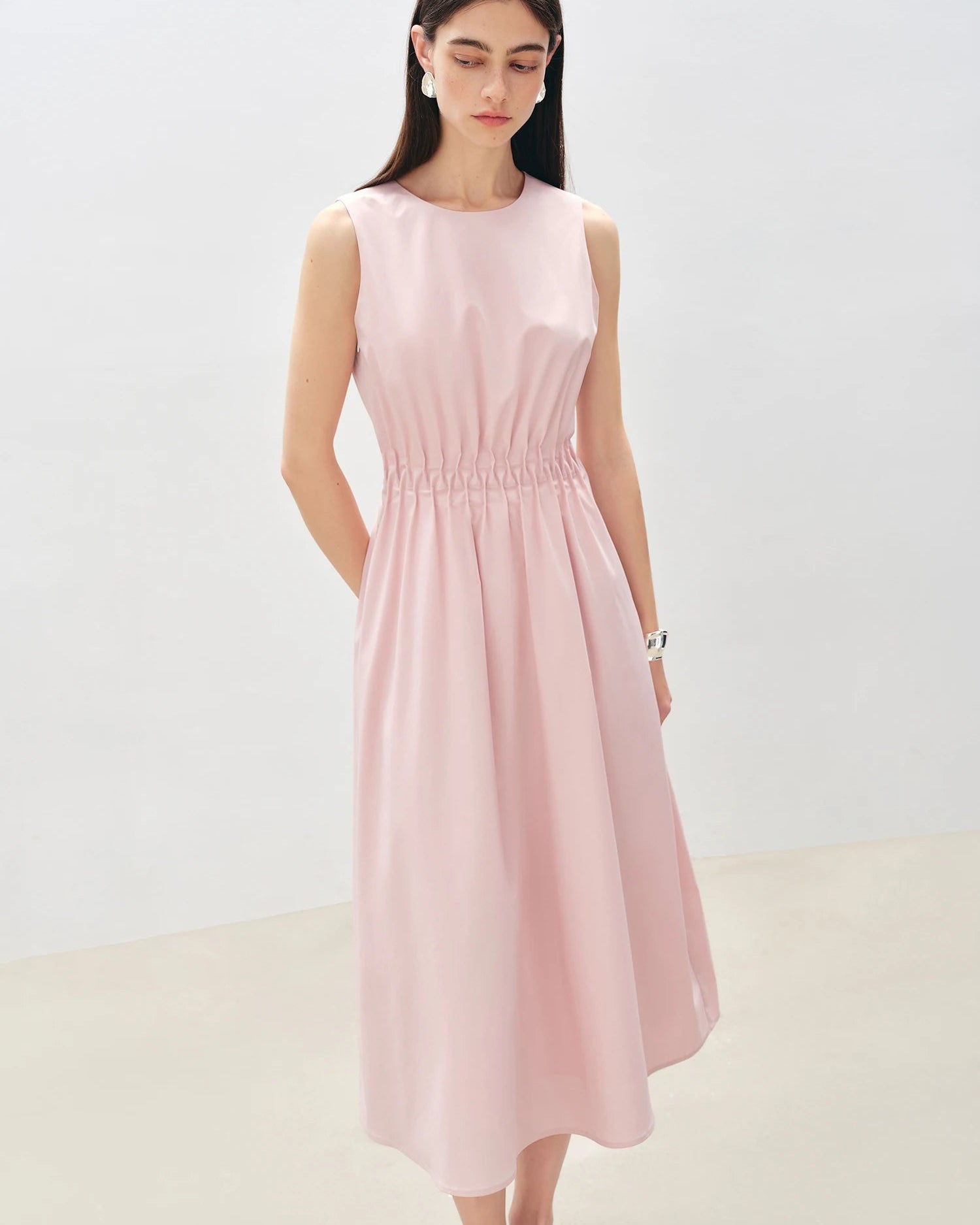 Women's sleeveless pleated A-line midi dress, featuring breathable fabric and cinched waist for summer office wear or resort vacation elegance.