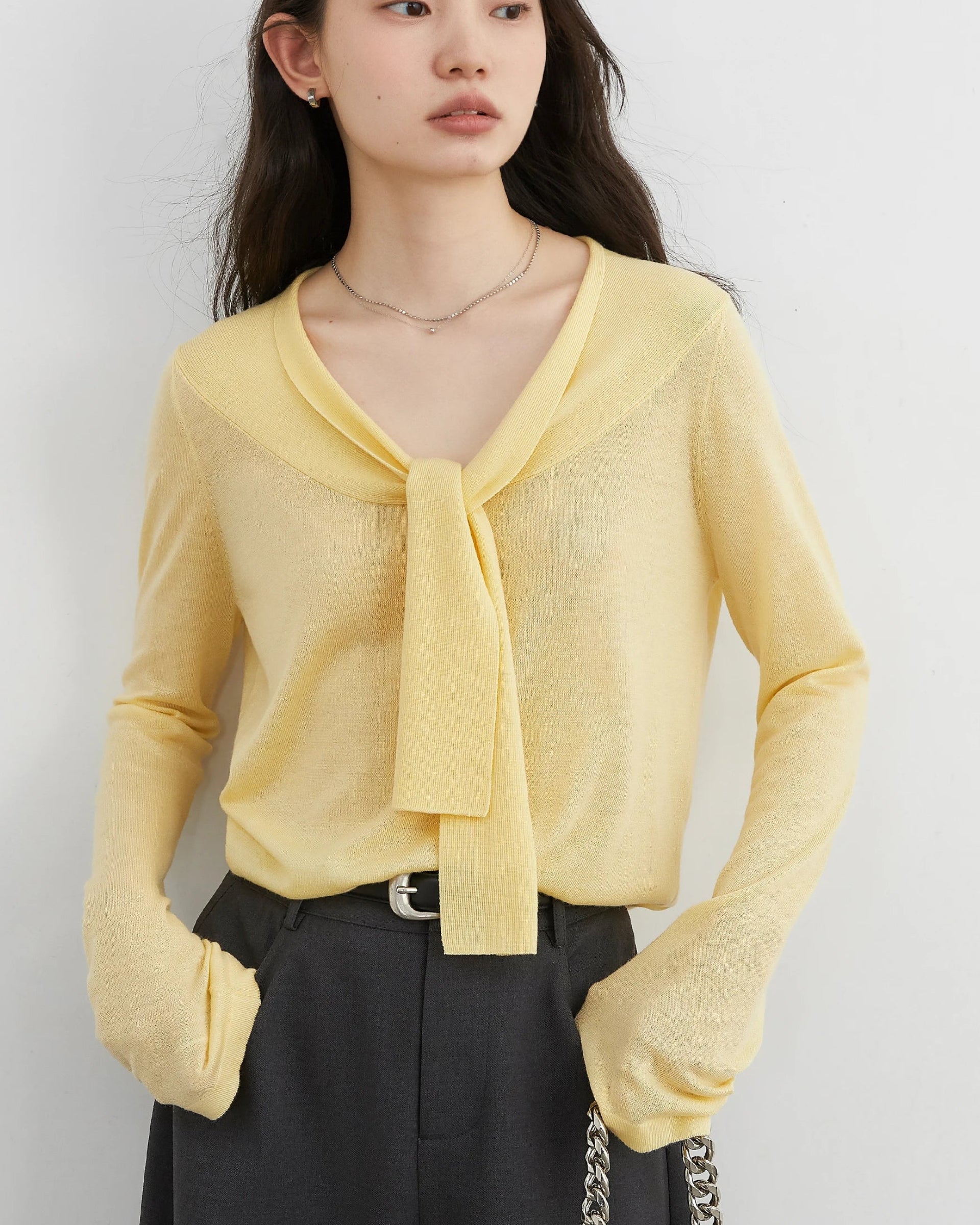 Relaxed V-neck pullover with lace-up detail, soft wool-cashmere blend, and breathable knit fabric. 