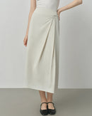 Textured cotton blend high-waisted A-line skirt featuring an elegant irregular hem and loose fit, perfect for office wear or casual autumn outfits in beige or black.
