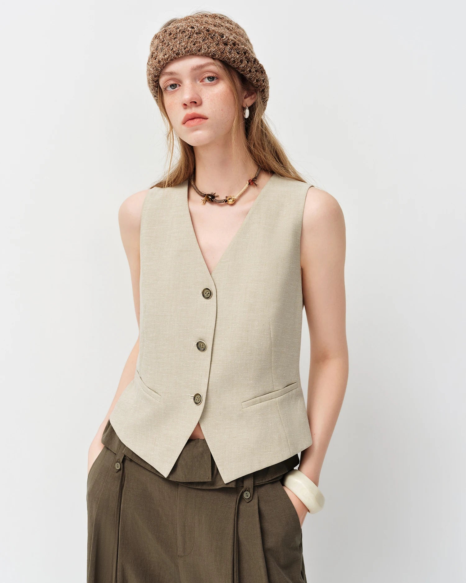 Women's woven sleeveless vest in a relaxed V-neckline silhouette, crafted from a breathable hemp-blend fabric, styled for effortless summer office dressing.