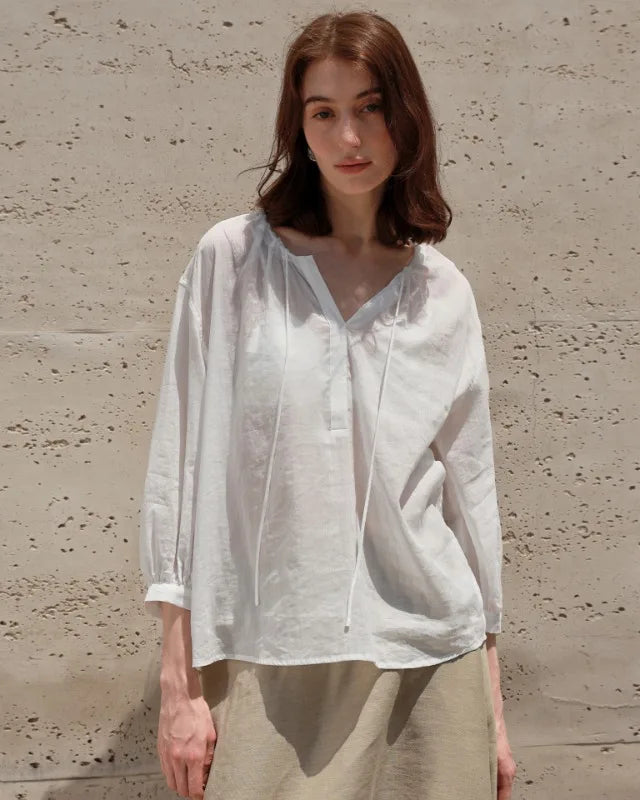 Lightweight ramie-lyocell blouse with V-neck & drawstring waist. Breezy nine-quarter sleeves for effortless casual style, beach days & holiday escapes.