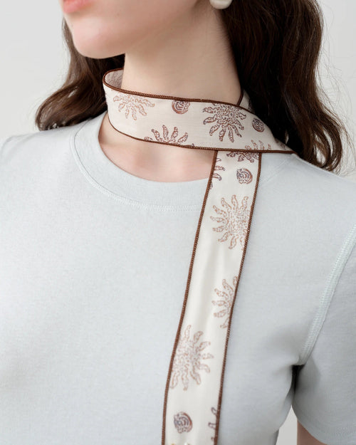 Women's brown printed beaded ribbon hair accessory, featuring lustrous Lyocell fabric and delicate beading for summer effortless elegance or special occasion styling.