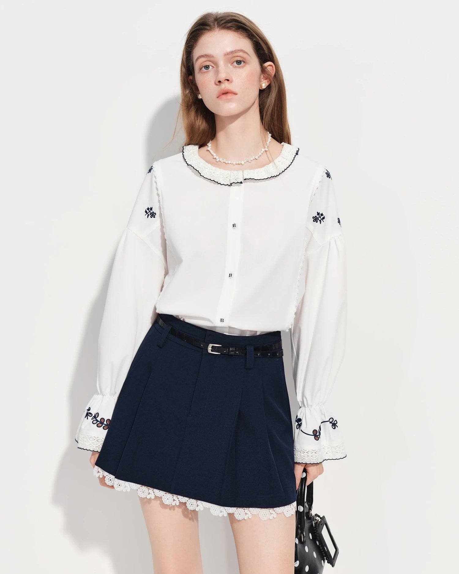 Vintage-inspired white shirt with delicate embroidered lace and a Peter Pan collar. Loose fit, flared sleeves .