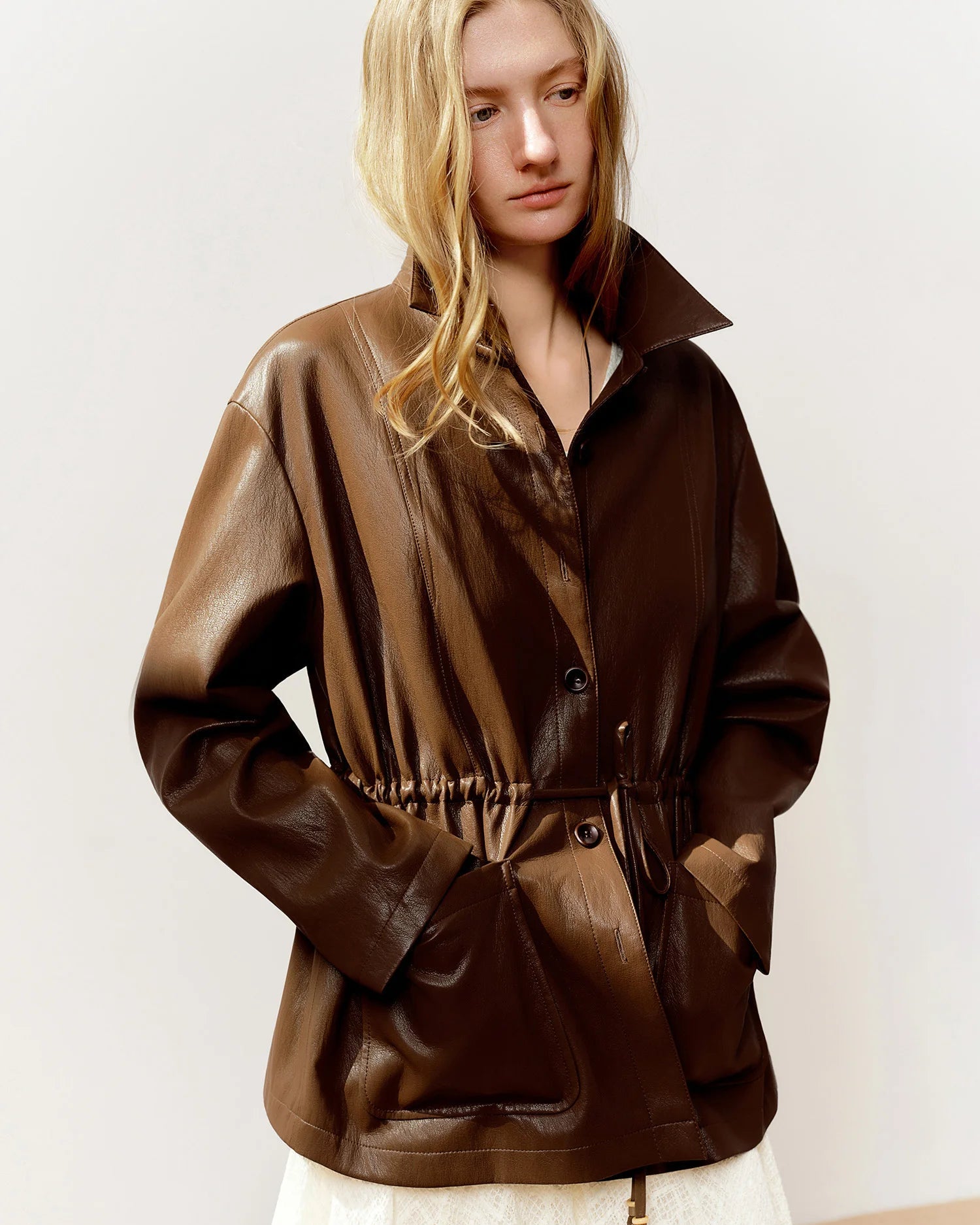 Cropped moto-style jacket in viscose-metallic blend with drawstring waist & turn-down collar. Flattering, fashion-forward outerwear for spring & autumn.