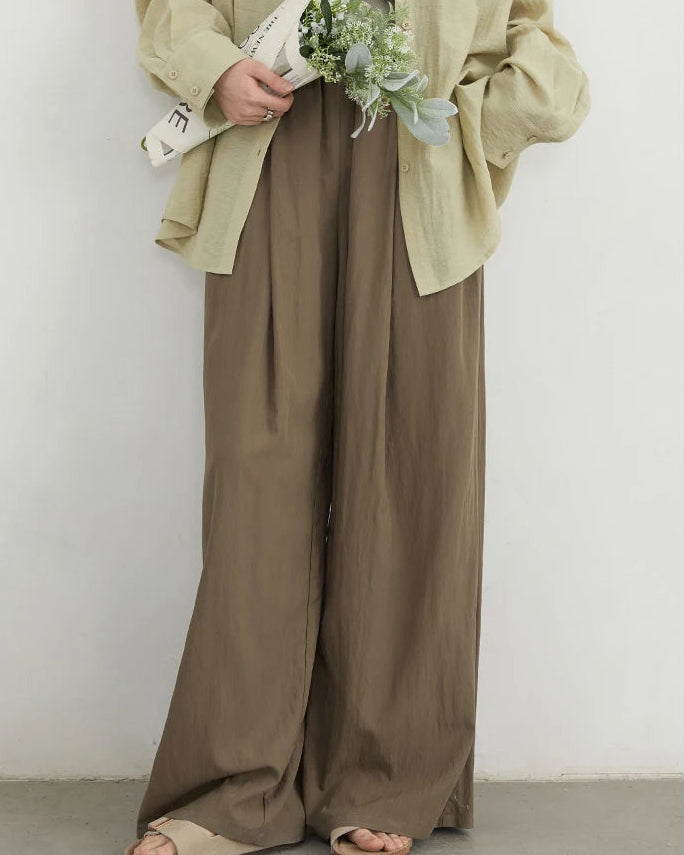 High-waist wide-leg trousers in viscose-nylon blend with elastic waist & pleated front. Lightweight, flowing drape for effortless spring-summer style.