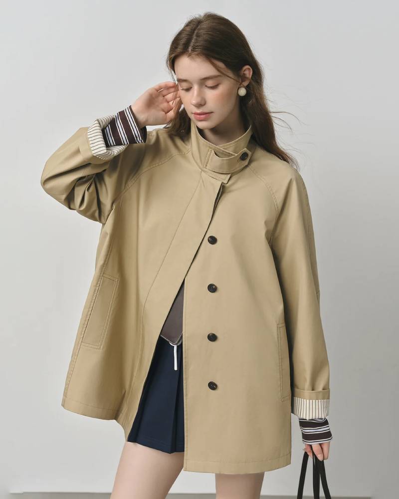 Lightweight sand-beige windbreaker trench jacket with stand collar, zip front and storm flap — spring-ready women’s raincoat by Gentle Herd.